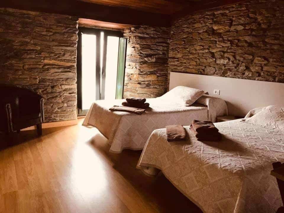 Habitación doble con pared de piedra en la pensión Siete en el Caminno Sarria